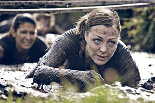 Muddy woman competing in an adventure race
